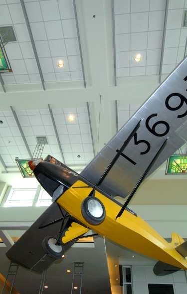A vintage yellow airplane hangs from the ceiling of the Dane County Regional Airport