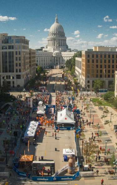 An aerial view of a downtown street festival with the Capitol building in the background.