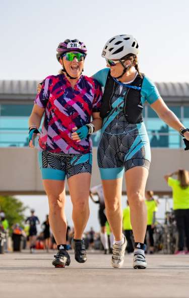 Two white women IRONMAN competitors help each other through the race