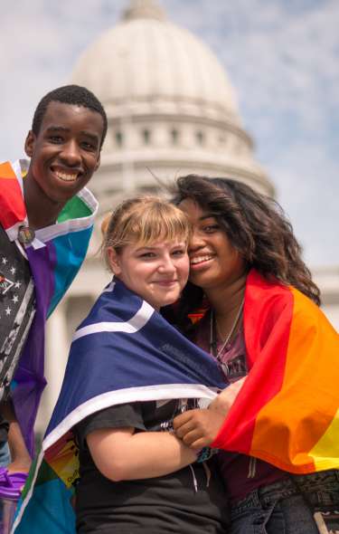 A group of people pose for a photo at a Pride parade