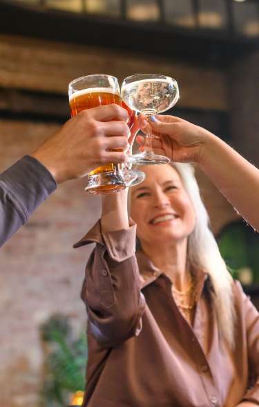 Two women and a man cheers cocktails at the Harvey House bar