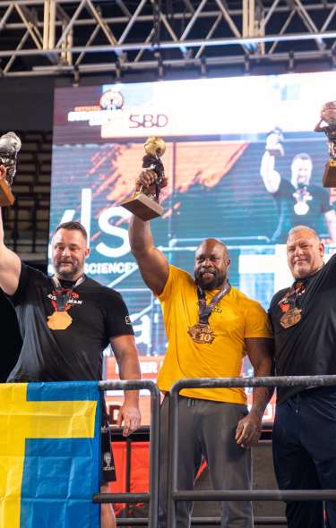 Athletes holding trophies at the Strongman Games at Alliant Energy Center