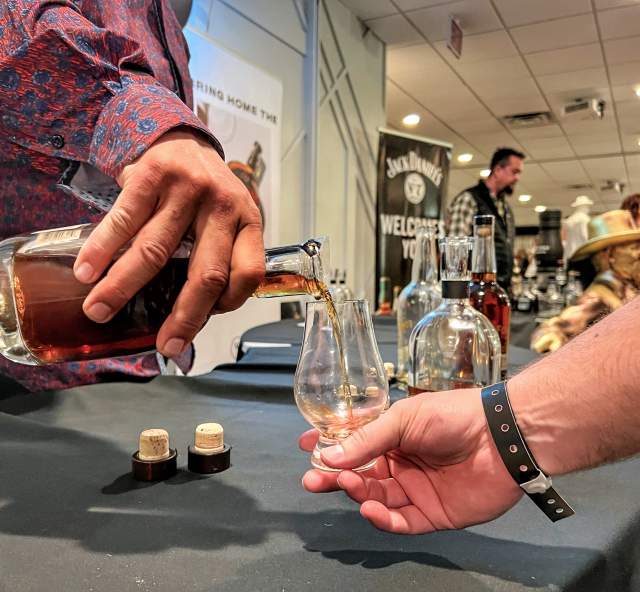 whiskey being poured into a tasting glass at the mountain west whiskey festival in rapid city, sd