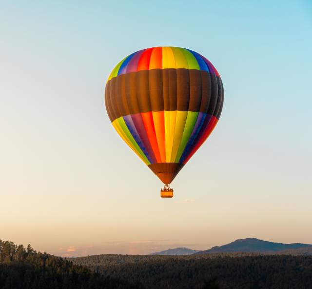 Black hills balloon stour hot air balloon taking flight with the sunrise over the black hills of south dakota