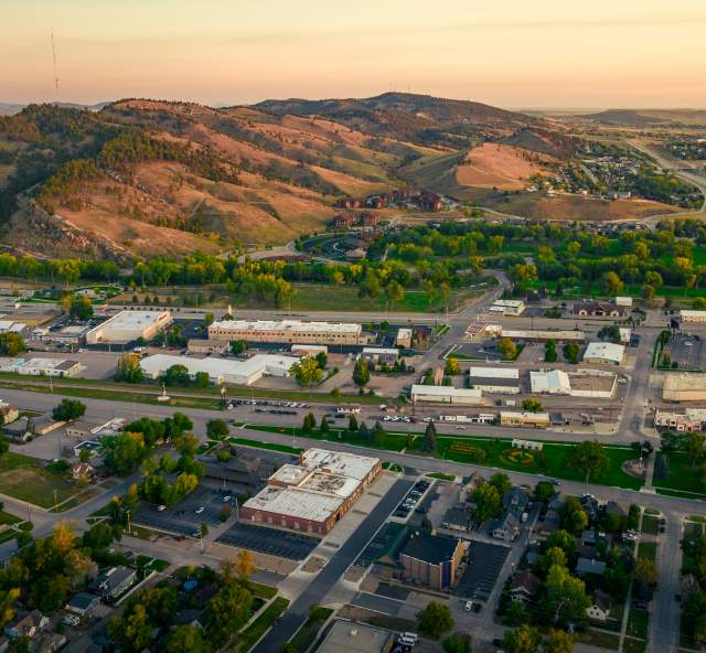Birds eye view of Rapid City with hill in the background during sunset
