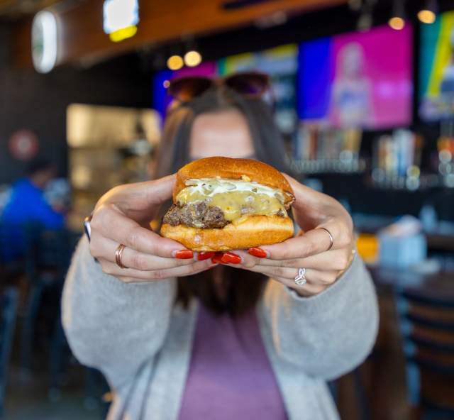 person holding up burger from salt block burger and brews in rapid city, sd