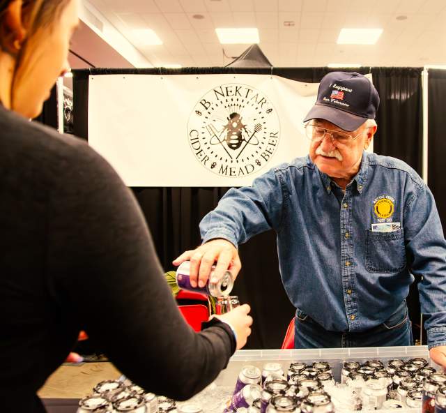 man pouring beer into glass for attendee of Mountain west beer festival in rapid city, sd