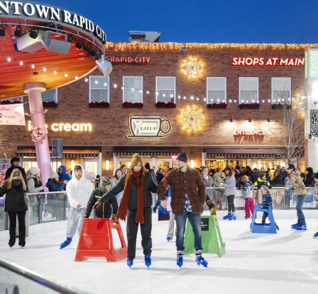 people ice skating at main street square in rapid city, sd during winter market event