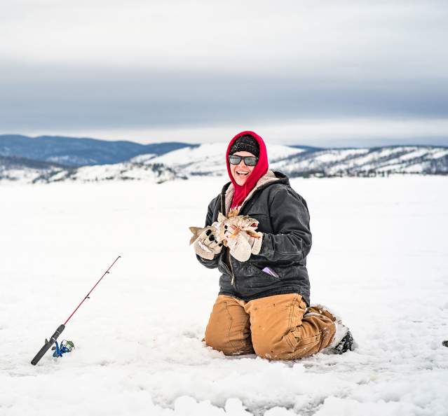 Woman holding fish at the 3 Lakes Ice Fishing Contest