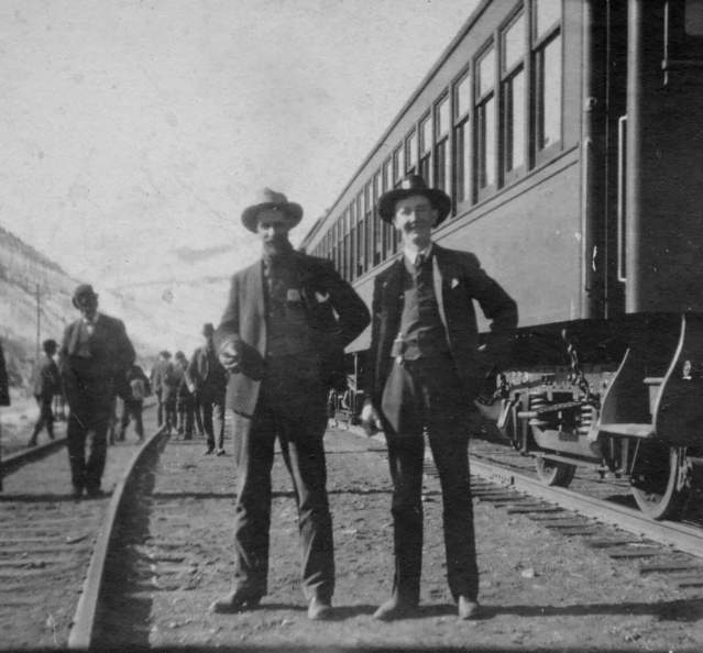 Historic photo of men in front of first train in Granby c. 1905