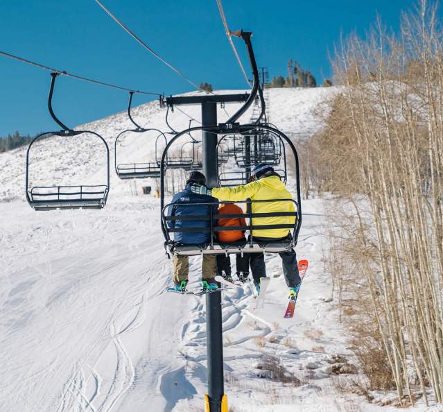 Skiers on chairlift at Granby Ranch