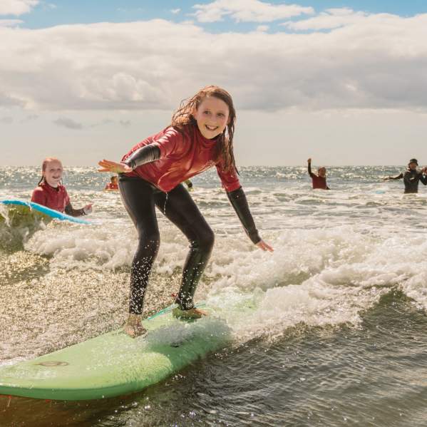 young girls surfing in rhossili bay