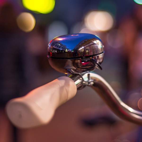 Photograph showing a bicycle handlebar with a traditional style bell mounted to it