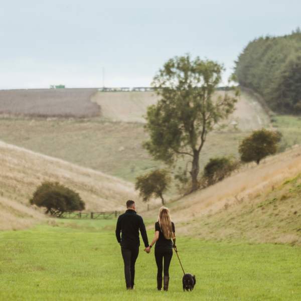 A couple with their dog walking on the Yorkshire Wolds