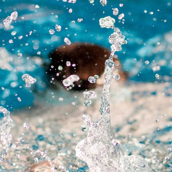 Photograph showing splashes in the water as a person swims in a pool