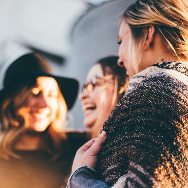 Photograph showing three women smiling as they enjoy a girls' holiday