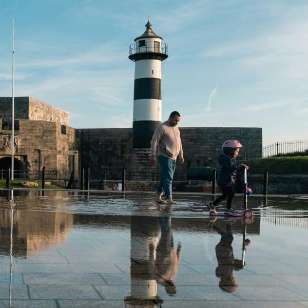 Photograph showing a parent and child at the water fountain outside Southsea Castle