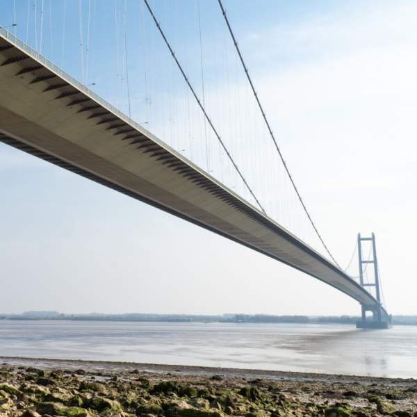 People walking on the foreshore under the Humber Bridge in East Yorkshire
