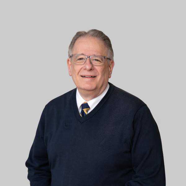 A man with gray hair and glasses standing