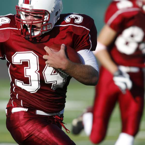 young man running with the ball during a football game