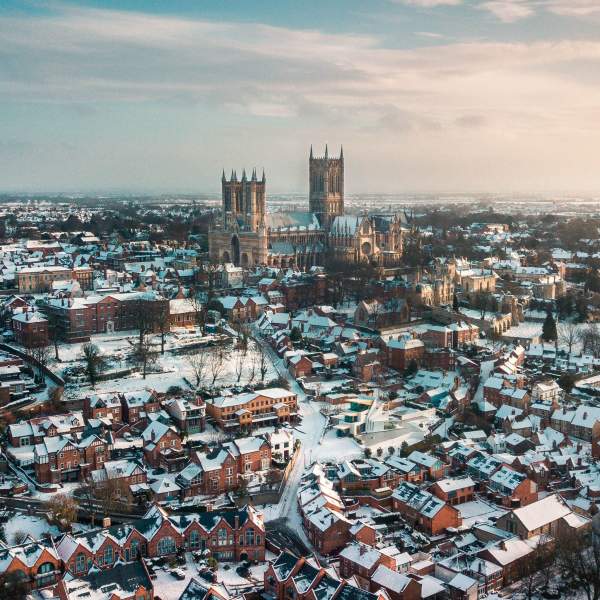 An aerial shot of Lincoln covered in snow, with Lincoln Cathedral in the distance