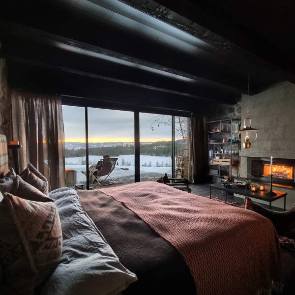 Bed and a winter view of Gjøvik in the stone Cabins at Kastad farm