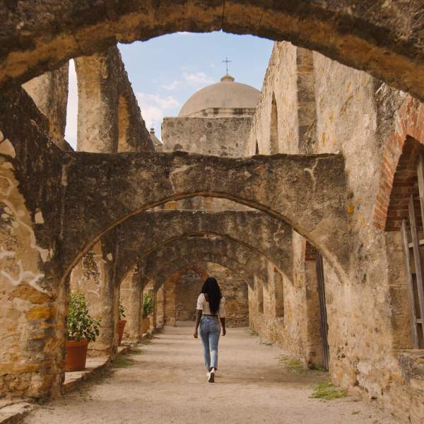 Woman walking through San Antonio Missions National Historial Park pathway