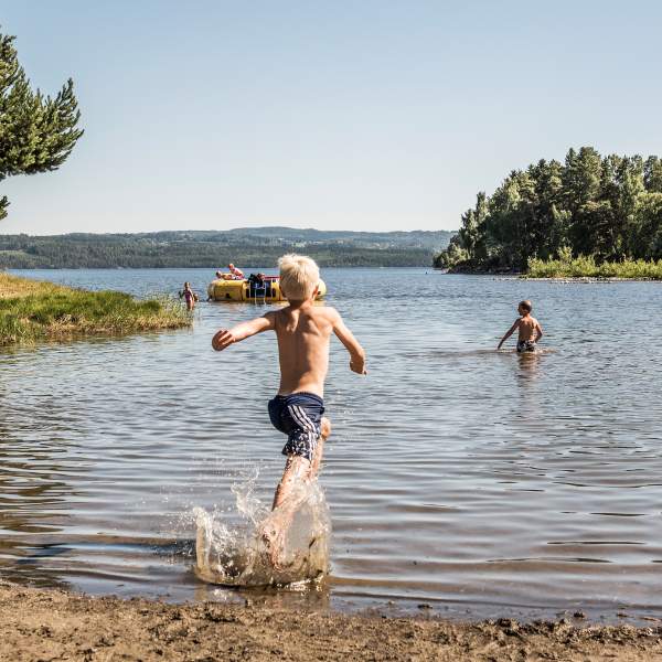 Ivrig gutt løper på sandstranden hos Sveastranda Camping