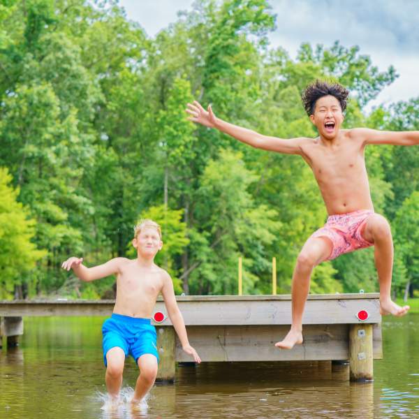 Two Boys Jumping Off a Pier at Cypress Black Bayou