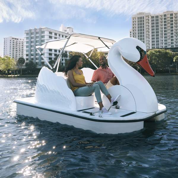 Couple exploring Lake Eola on a swan boat