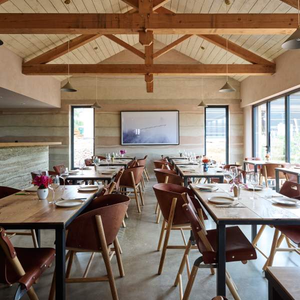 Interior view of wooden tables, chairs and beams in Knepp Wilding kitchen restaurant