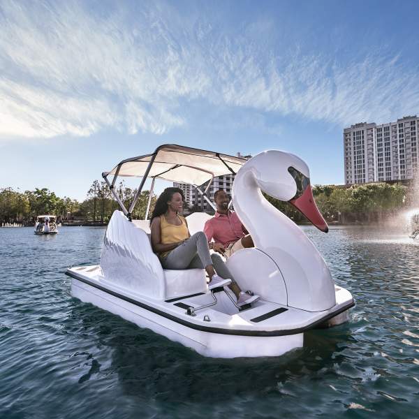 A couple exploring Lake Eola on a swan boat