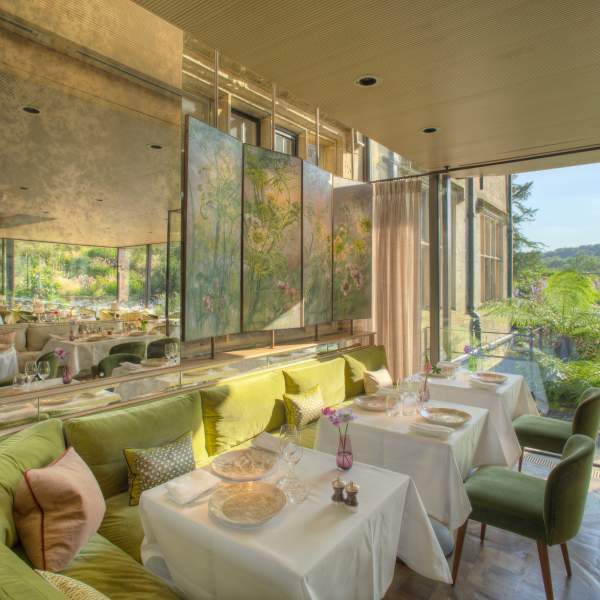 Interior tables at Gravetye Manor restaurant, with patio doors leading out to gardens