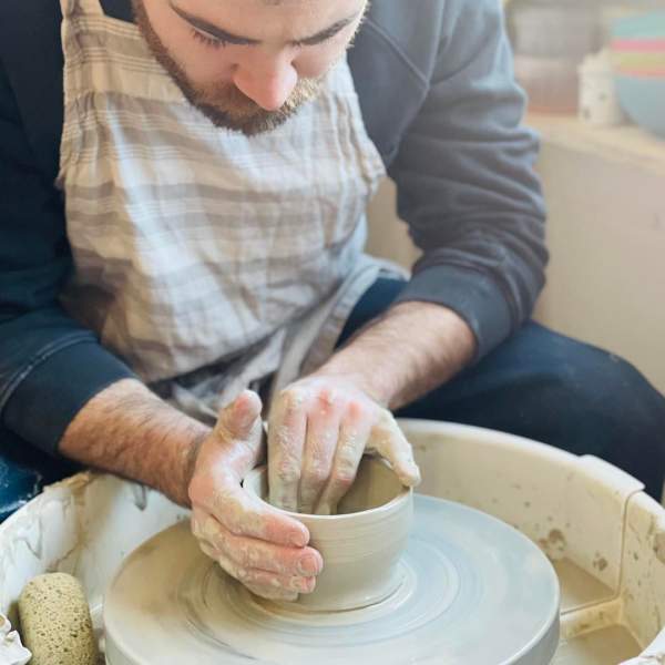 people working on a pottery wheel