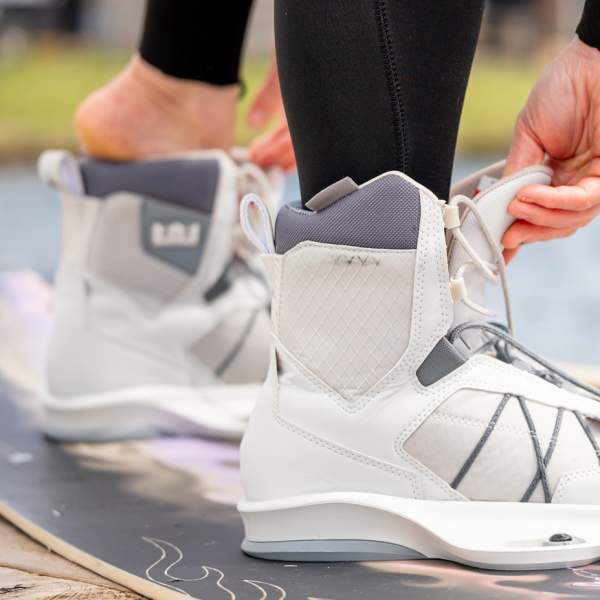A close up shot of a wakeboarder putting on their boots
