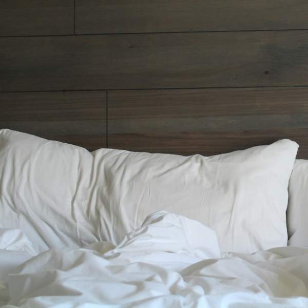 White bedding against a wood-panelled wall