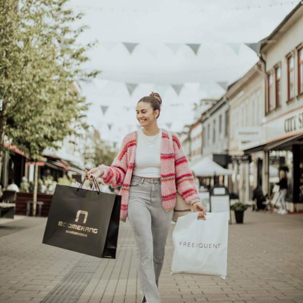 Kvinne på handleposer i hver hånd i gågata i Sarpsborg. Foto.