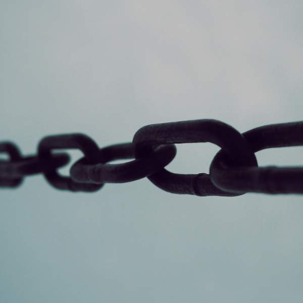 Photograph of a metal chain against a blue background