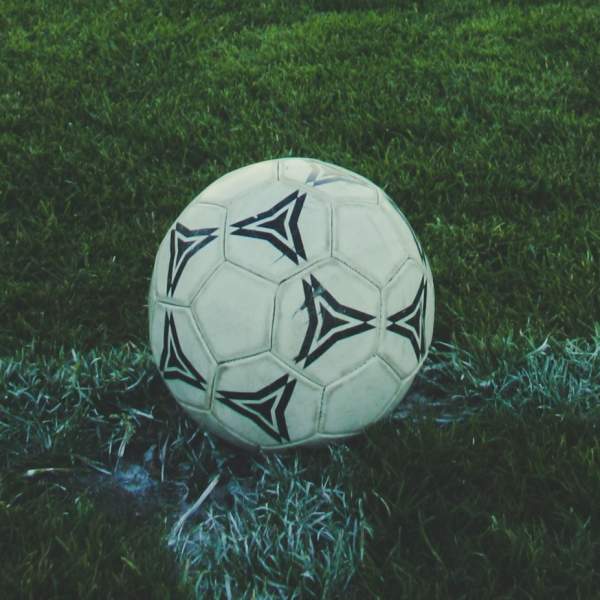 Photograph of a black and white football on a pitch