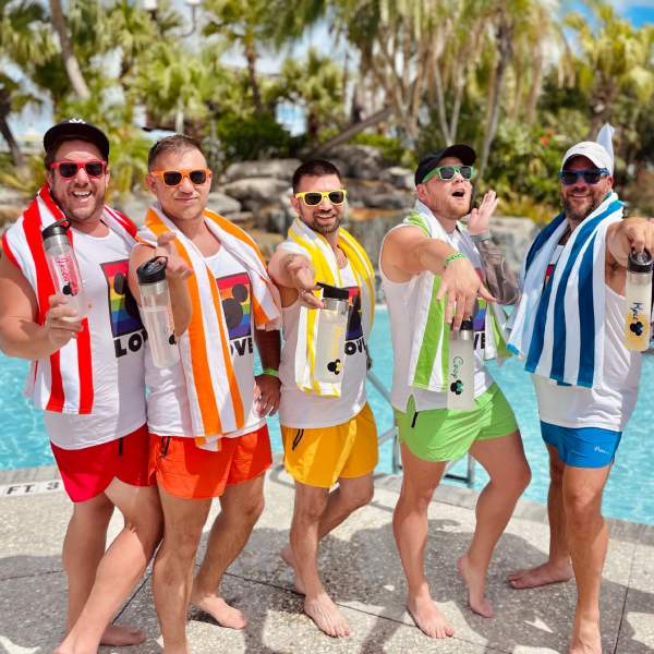 Group of men at pool dressed in rainbow colors.