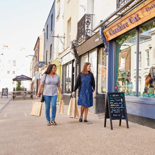 Two people walking past a shop in the pedestrain area of Carlton Place