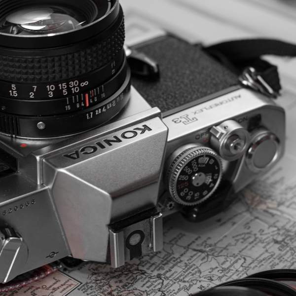 Photograph of a Konica camera and peripherals, on top of a map