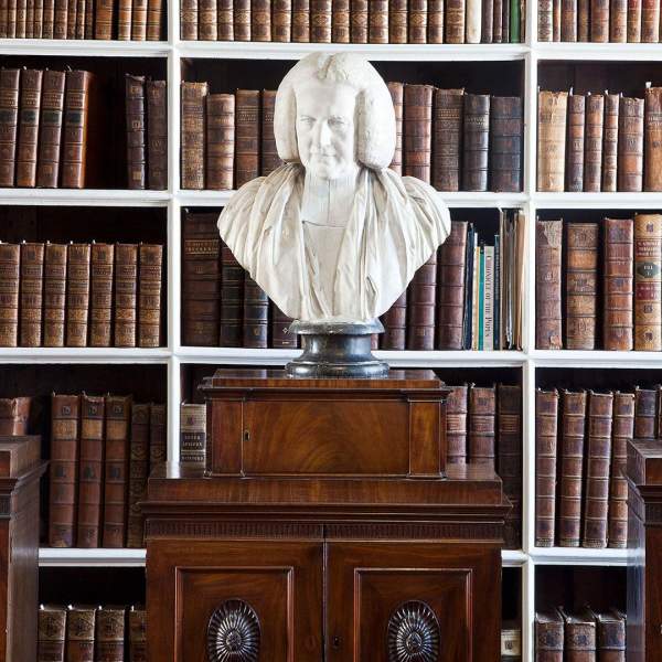 Bust on display in the Armagh Robinson Library with a row of books behind it