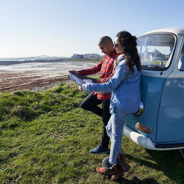 A couple look at a map while parked up overlooking Strangford Lough