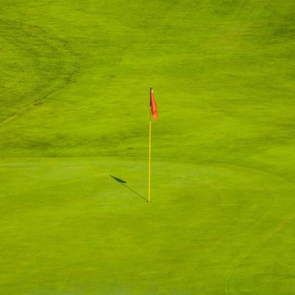 A final green at a golf course with a red flag