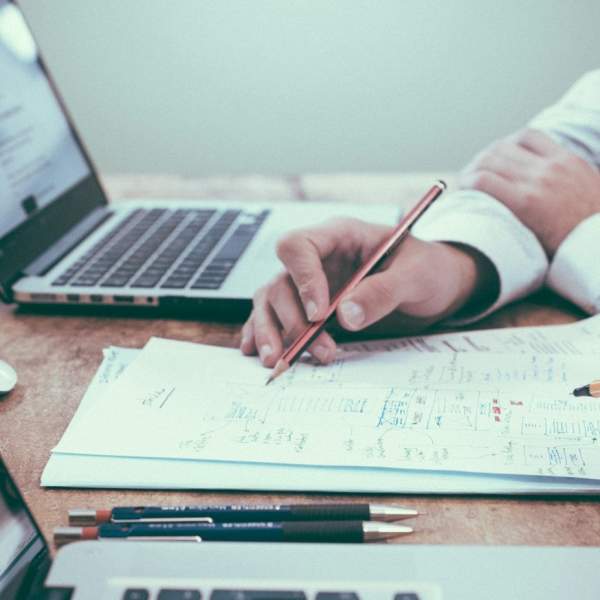Photograph of people studying with paper and laptops