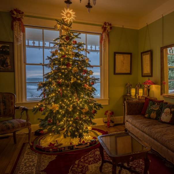 A lighted Christmas tree adorns a living room decorated for Christmas at the Heceta Head Bed and Breakfast.