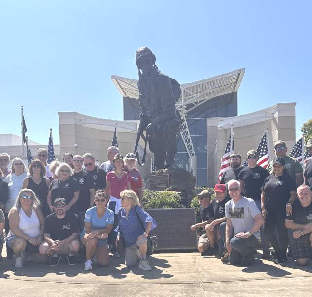 Military reunion group gathered in front of the Airborne & Special Operations Museum statue in Fayetteville, North Carolina