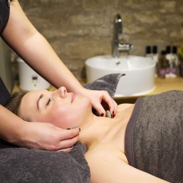 A woman relaxes with a hot stone massage at the Vaulted Spa at the Kings Head in the Cotswolds