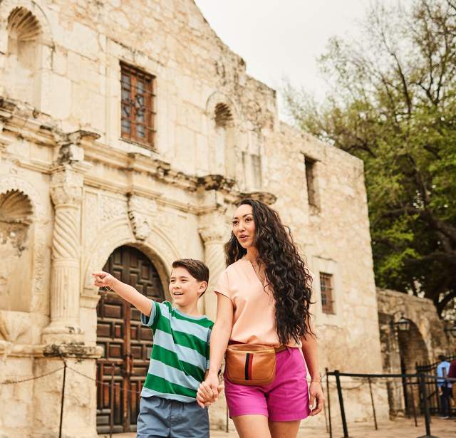 Mother and son holding hands in front of the Alamo